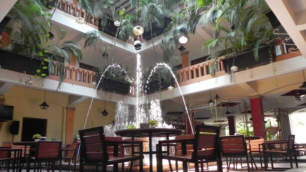 A spacious indoor area with a central fountain, multiple levels with balconies, and numerous seating arrangements. - Hotel Posada Del Sol (Apatzingan)