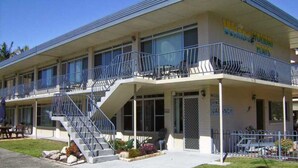 A two-story motel with a balcony on the second floor, a staircase leading to the entrance, and a 'No Vacancy' sign. - Wards Holiday Flat 7 (SOUTH WEST ROCKS)