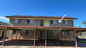 A two-story building with a flat roof, a sign for Clarke's Holiday Units, and a covered parking area. - Clarkes Flat 4 - walk to the beach (South West Rocks)