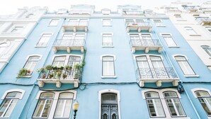 A multi-story building with a blue facade, white trim, and multiple balconies with railings. - Estrela Neoclassical Apt River View (Lisbon)