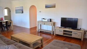 Un soggiorno con un tavolino in legno, due divani, un mobile TV con televisore a schermo piatto e un impianto audio.