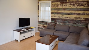 Relax in this cozy space with a flat-screen TV, comfortable sofa, and a rustic charm.