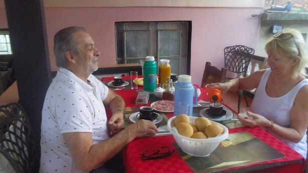 A dining table with a red tablecloth, a bowl of bread, and various condiments. - Casa Yaquelin y Osmani (Viñales)