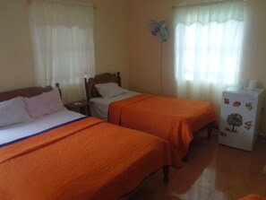 A room with two beds, a nightstand, a fan, and a refrigerator. - Casa Yaquelin y Osmani (Viñales)