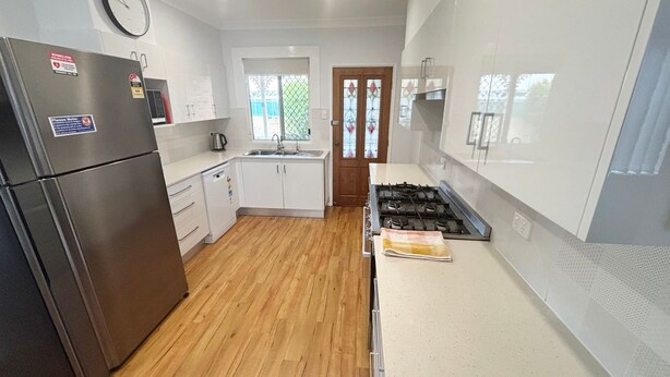 A modern kitchen with a refrigerator, stove, sink, and wooden flooring. - Mountain View Hat Head - Bring your own linen (HAT HEAD)