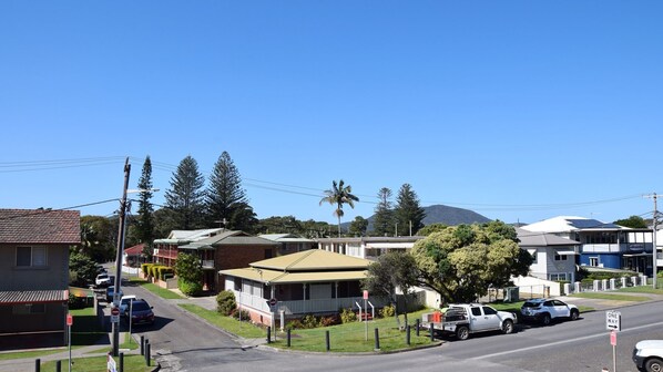 A residential street with houses, a parked truck, and a clear blue sky.