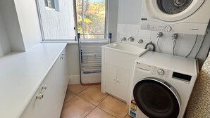 A laundry room with a washing machine, dryer, and a drying rack. - Ocean Shores Apartment 15 - Bring your own linen (SOUTH WEST ROCKS)