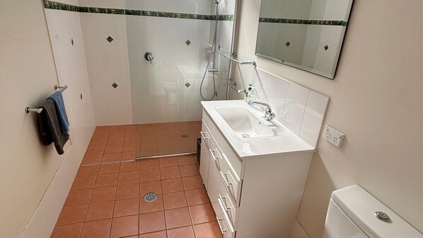 A bathroom with a shower, a sink, and a toilet. - Blue Diamond Escape - Walk to the beach (ARAKOON)