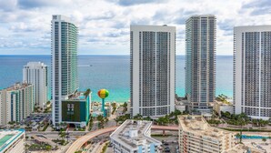 A high-rise hotel with multiple floors, a swimming pool, and a view of the ocean. - Private Ocean Luxury Condos at Beachwalk (Hallandale Beach)