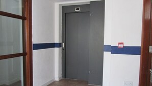 A hallway with a closed door, a glass door on the left, and a wall with a blue stripe. - Sea View Apartment   situated on the seafront near the village Salthill (Galway)