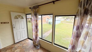 A room with a door, a window, and a view of a yard. - Bundi Hat Head - walk to the beach - Bring your own linen (HAT HEAD)