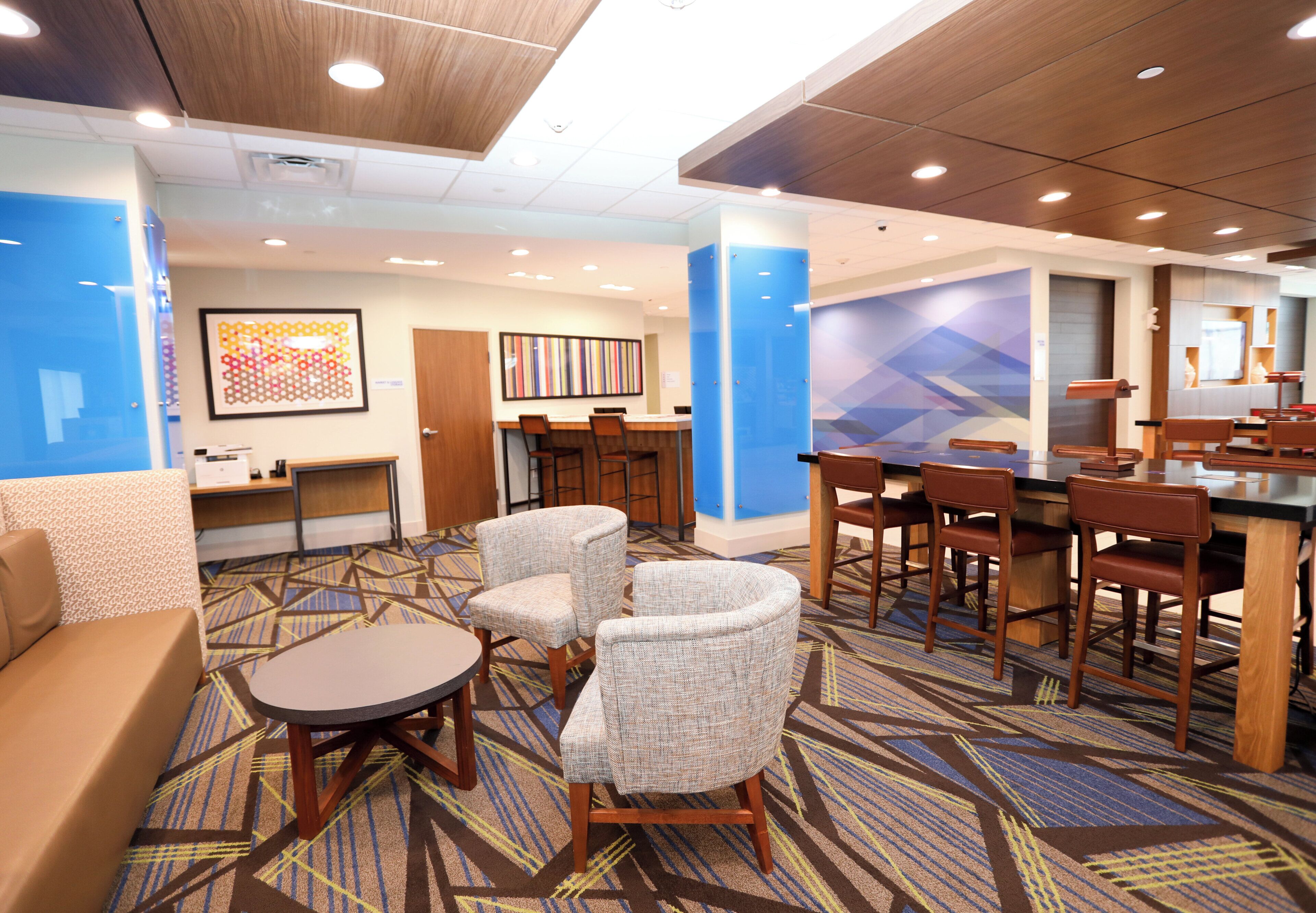 A hotel lobby with a seating area, a reception desk, and a bar.