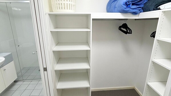 A white closet with multiple shelves and a hanging rod.
