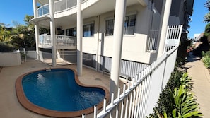En boligbygning med swimmingpool, altaner og et indhegnet område.
