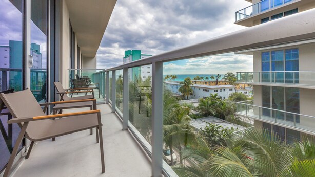 A balcony with a view of the cityscape and palm trees. - Private Luxury Condos at Costa Hollywood (Hollywood)