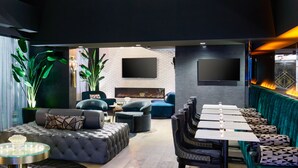 A modern interior with a dining area, sofas, and a large chandelier. - The Kindler Hotel (Lincoln)