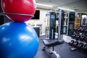 A gym with exercise balls, dumbbells, and weight machines. - The Kindler Hotel (Lincoln)
