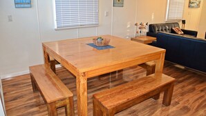 Una mesa de madera con bancos, una cesta y un mantel individual azul.
