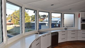 Una cocina moderna con ventanas amplias, lavavajillas y microondas.