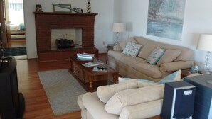 Una sala de estar con chimenea, un sofá, una mesa de centro y un cuadro en la pared.