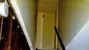 Una escala de fusta amb barana que condueix a una porta a la part superior.