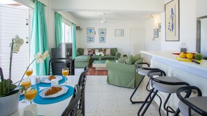 A compact living space with a dining area, a sofa, and a kitchenette. - Protaras Annie Suite (Paralimni)
