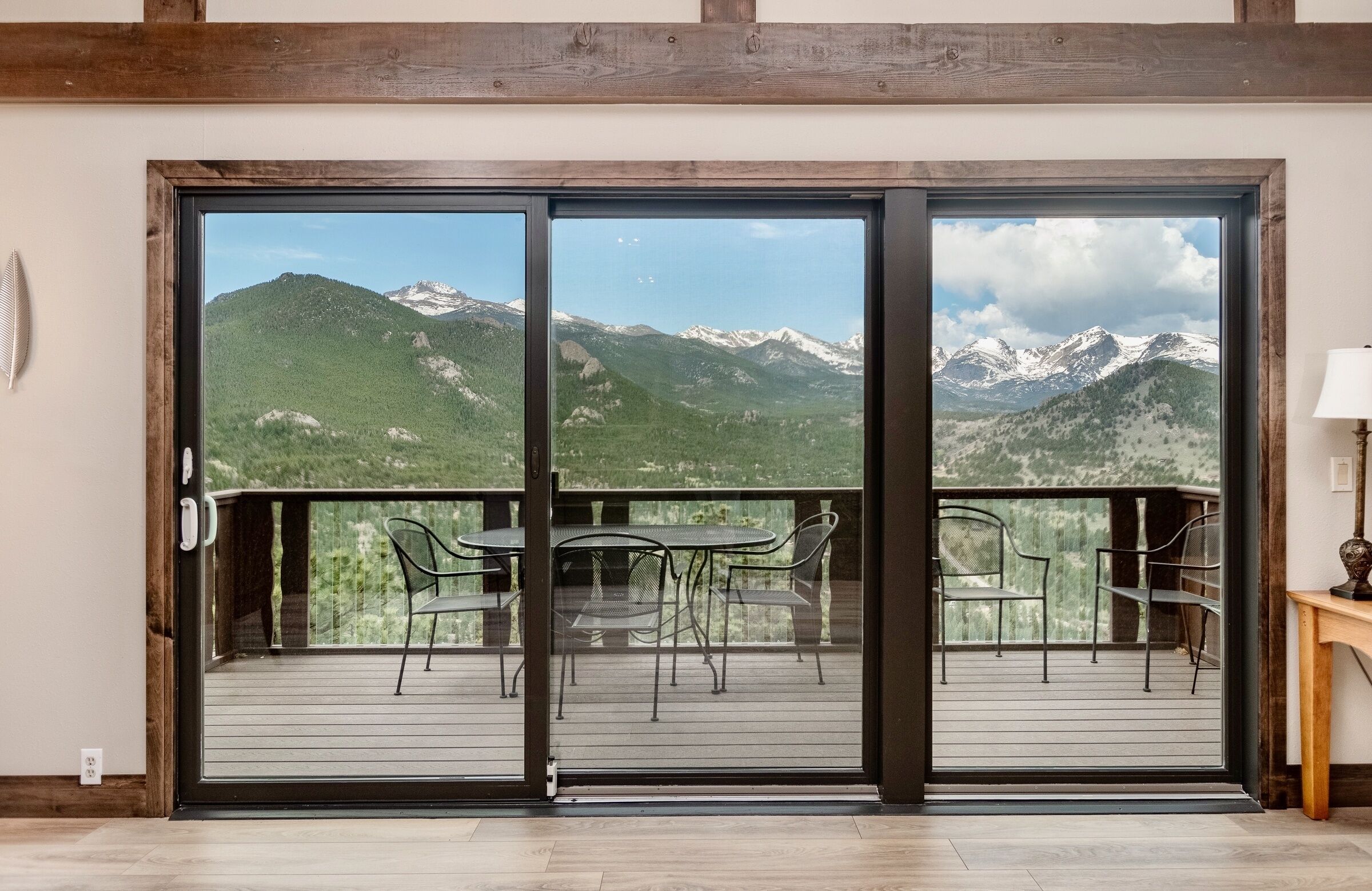 A balcony with a mountain view, featuring a table and chairs.