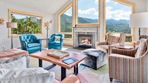 Un salón amplio con ventanas grandes, una chimenea y asientos cómodos.