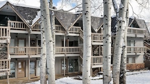 A multi-story building with a symmetrical design, featuring balconies and large windows. - Timber Ridge Unit 2e 1 Bedroom Condo by RedAwning (Aspen)