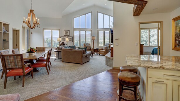 A spacious living area with a dining table, sofas, and a kitchen area with a marble countertop. - 2br In The Seasons At Arrowhead-vaulted Ceilings 2 Bedroom Condo by RedAwning (Edwards)