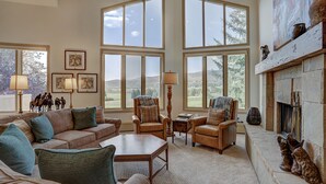 A spacious living room with large windows, a fireplace, and a view of the outdoors. - 2br In The Seasons At Arrowhead-vaulted Ceilings 2 Bedroom Condo by RedAwning (Edwards)