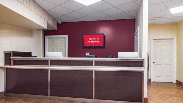 A reception desk with a sign indicating free Wi-Fi in all rooms. - Red Roof Inn Perrysburg (Perrysburg)