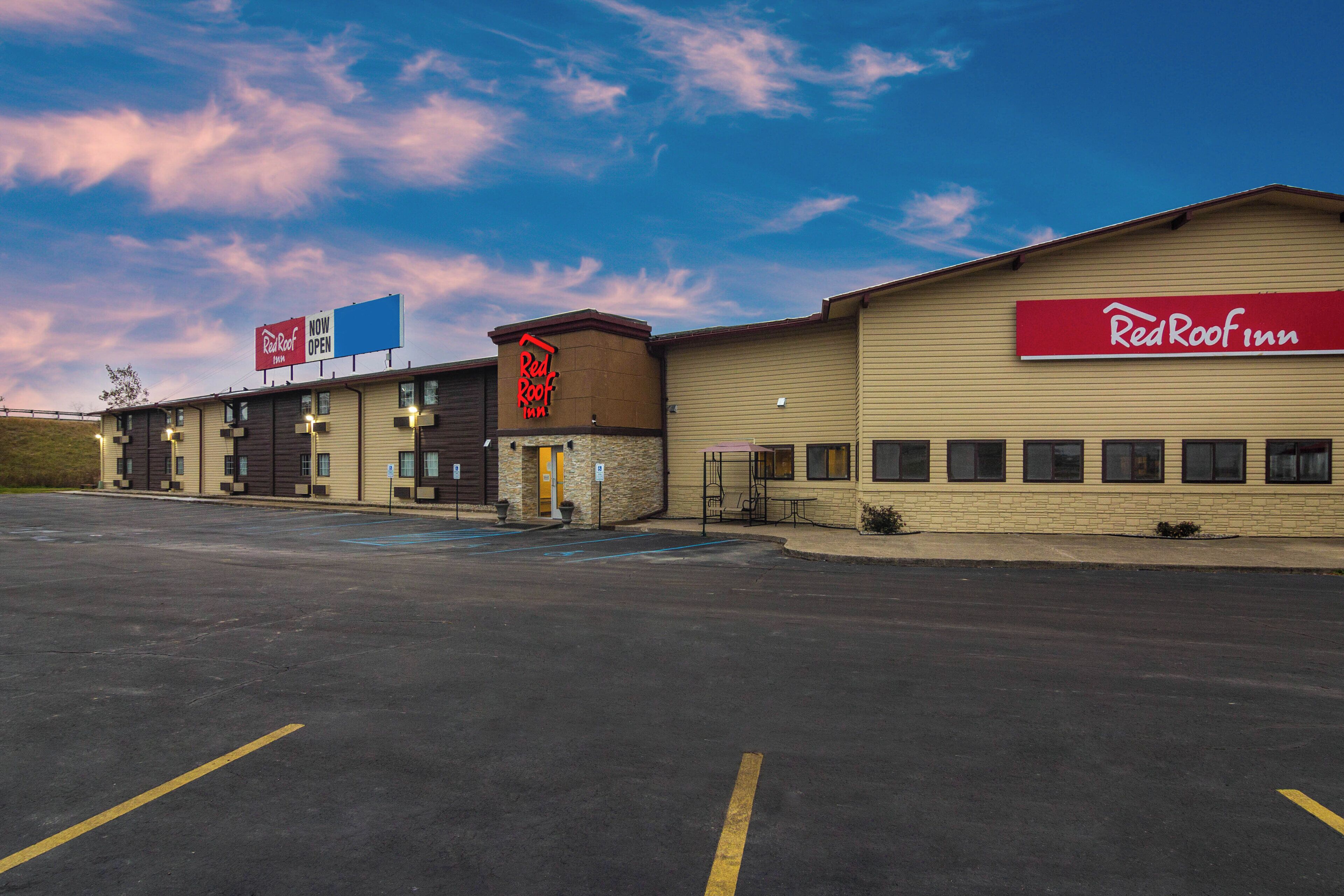 Ein Red Roof Inn mit Parkplatz und mehreren Gebäuden.
