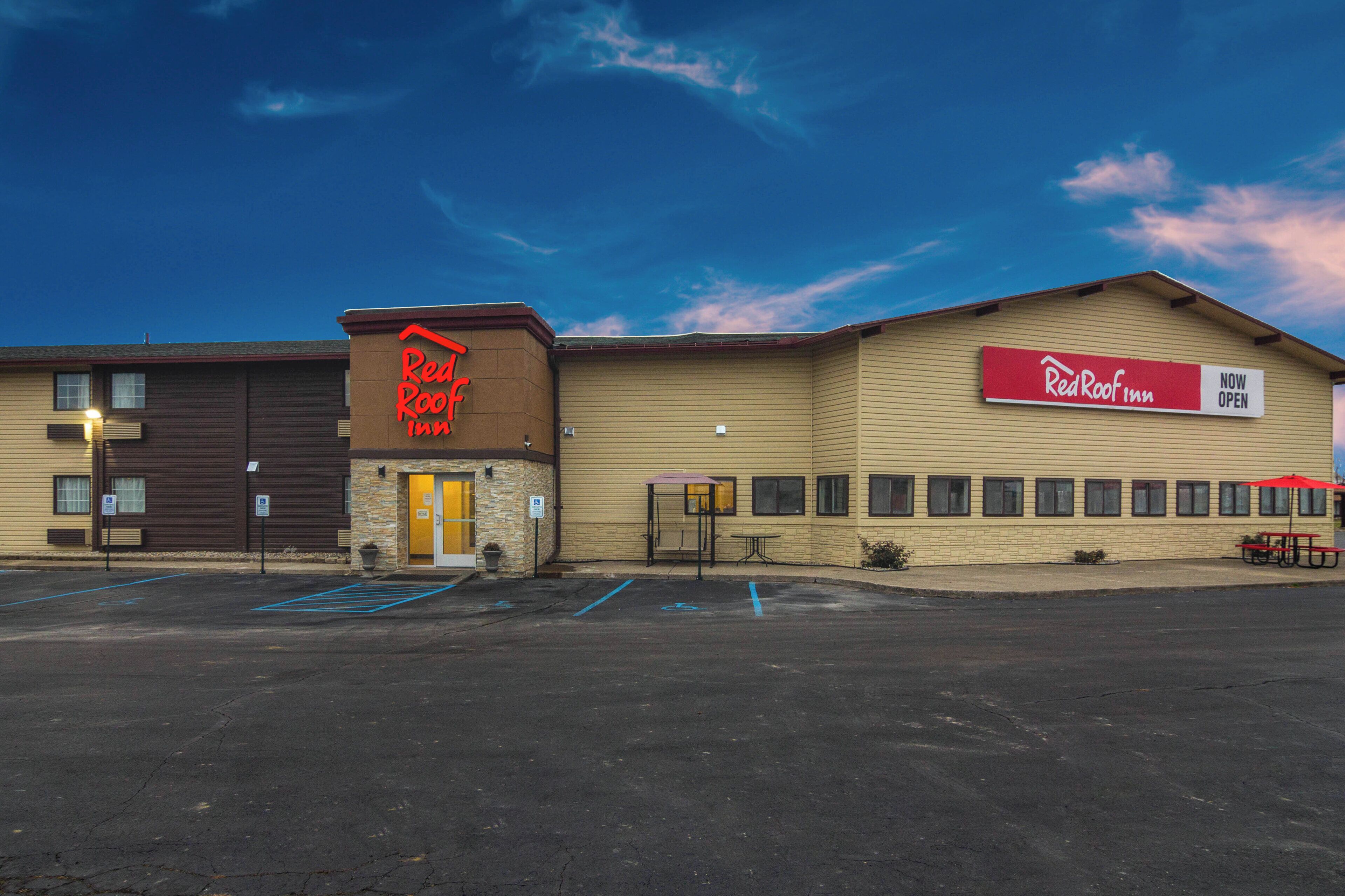 A Red Roof Inn with a parking lot and a Red Roof sign.