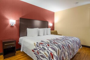 A hotel room with a large bed, two bedside tables, and a nightstand. - Red Roof Inn Perrysburg (Perrysburg)