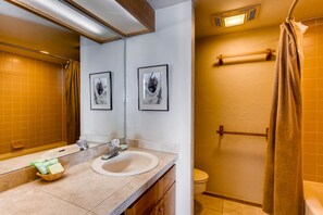 A bathroom with a sink, mirror, and two framed pictures on the wall. - Ski-in/ski-out 2 Br - Sleeps 6 People 2 Bedroom Condo by RedAwning (Crested Butte)