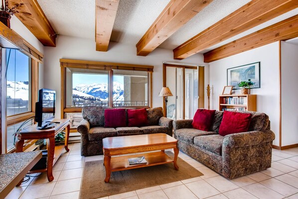 Relax in a cozy living room with a scenic view, comfortable seating, and entertainment options.