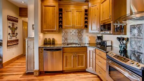 A kitchen with wooden cabinets, a dishwasher, a stove, and a microwave. - Unique & Modern 3 Br/2ba - Ski-in/ski-out 3 Bedroom Condo - No Cleaning Fee! by RedAwning (Crested Butte)