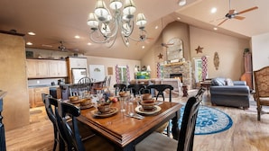 A spacious living room with a dining area, a fireplace, and a kitchen in the background. - Enchanted Primrose 2 Bedroom Chalet by RedAwning (Sevierville)