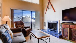 A living room with a sofa, a chair, a coffee table, a fireplace, and a television. - 1 Br + Loft With Mountain Views 1 Bedroom Condo - No Cleaning Fee! by RedAwning (Crested Butte)