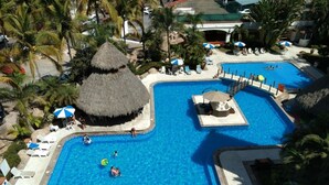 A large outdoor swimming pool with multiple lanes, surrounded by lounge chairs and umbrellas.