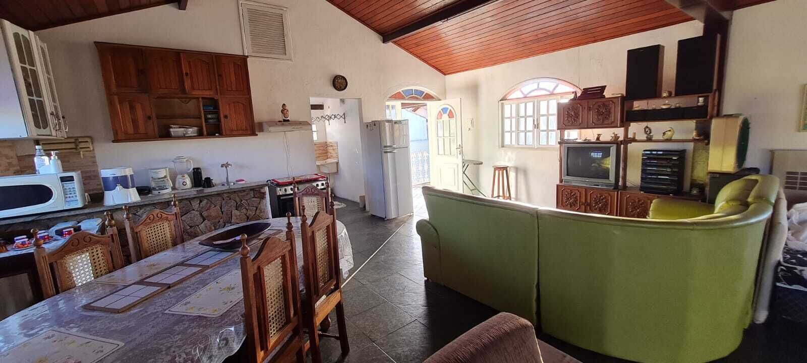 Een ruime keuken met houten kastjes, een eettafel met stoelen en een groene bank.