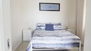 A bedroom with a bed, two bedside tables, a nightstand, and a framed artwork on the wall. - **Blue Point Cottage No 2 Bermagui** (Bermagui)
