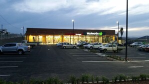 A parking lot with several cars parked in front of a building with a sign that reads "Bermagud" and "Woolworths". - **Blue Point Cottage No 2 Bermagui** (Bermagui)