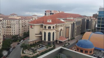 Un edificio de varios pisos con techo de tejas rojas, ventanas grandes y un patio central.