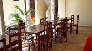 Un comedor espacioso con una larga mesa de madera y múltiples sillas.