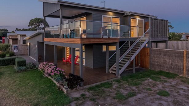 A modern two-story house with a balcony, a staircase, and a fenced backyard. - 7 Boardwalk Lakeside in Cowes (Cowes)