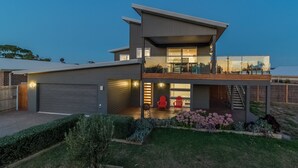 A modern two-story house with a covered patio, a garage, and a well-maintained garden. - 7 Boardwalk Lakeside in Cowes (Cowes)