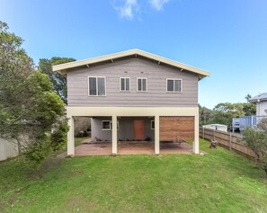 A two-story house with a covered patio and a garage.