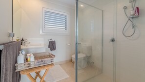 A bathroom with a glass shower enclosure, a toilet, a sink with a mirror, and a towel rack. - 7 Graydens with views in Ventnor (Ventnor)
